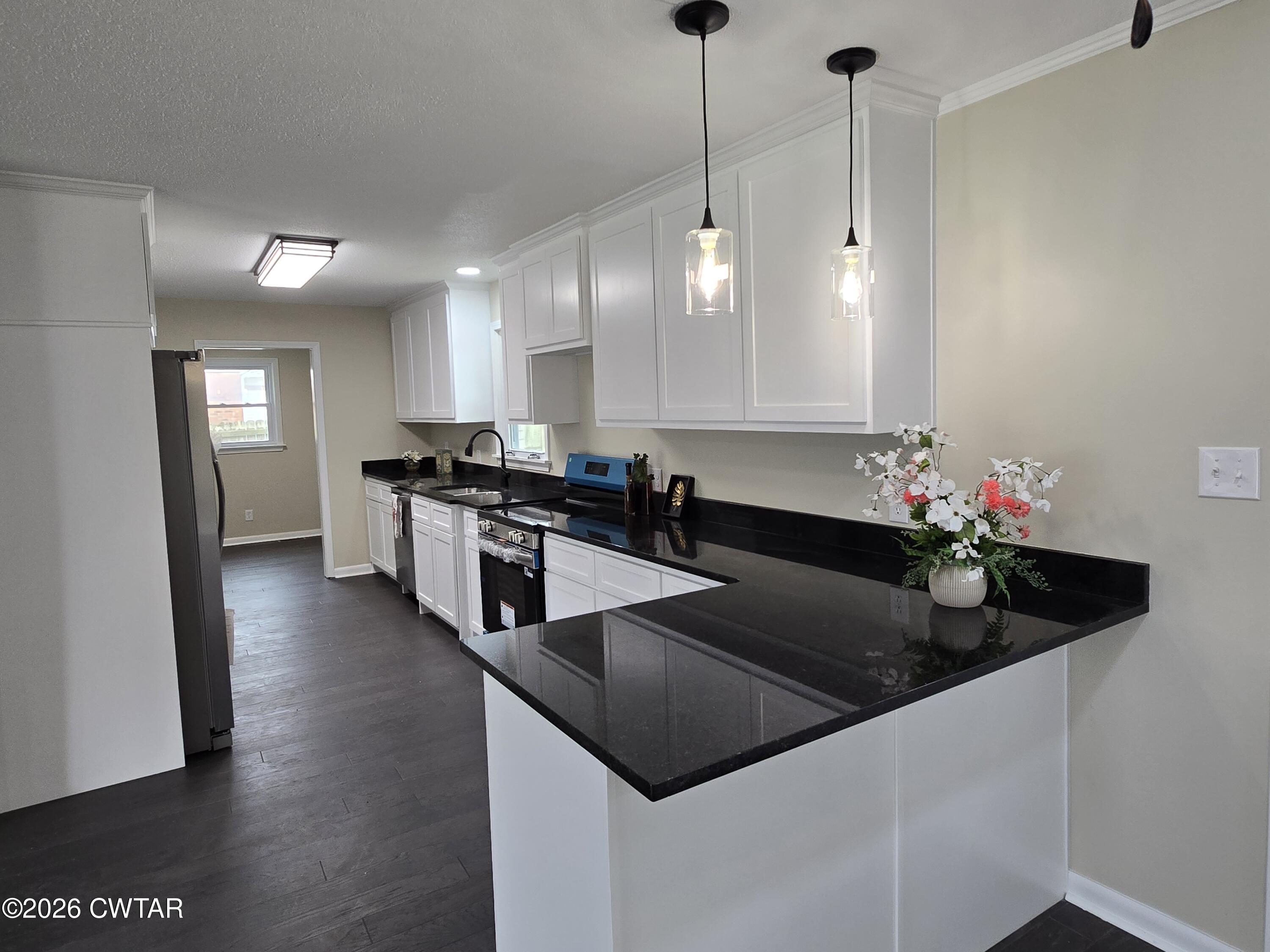 49 Brenda Lane Jackson, TN 38301 - Photo 10 of 23 a kitchen with granite countertop stainless steel appliances a sink a counter top space cabinets and wooden floor