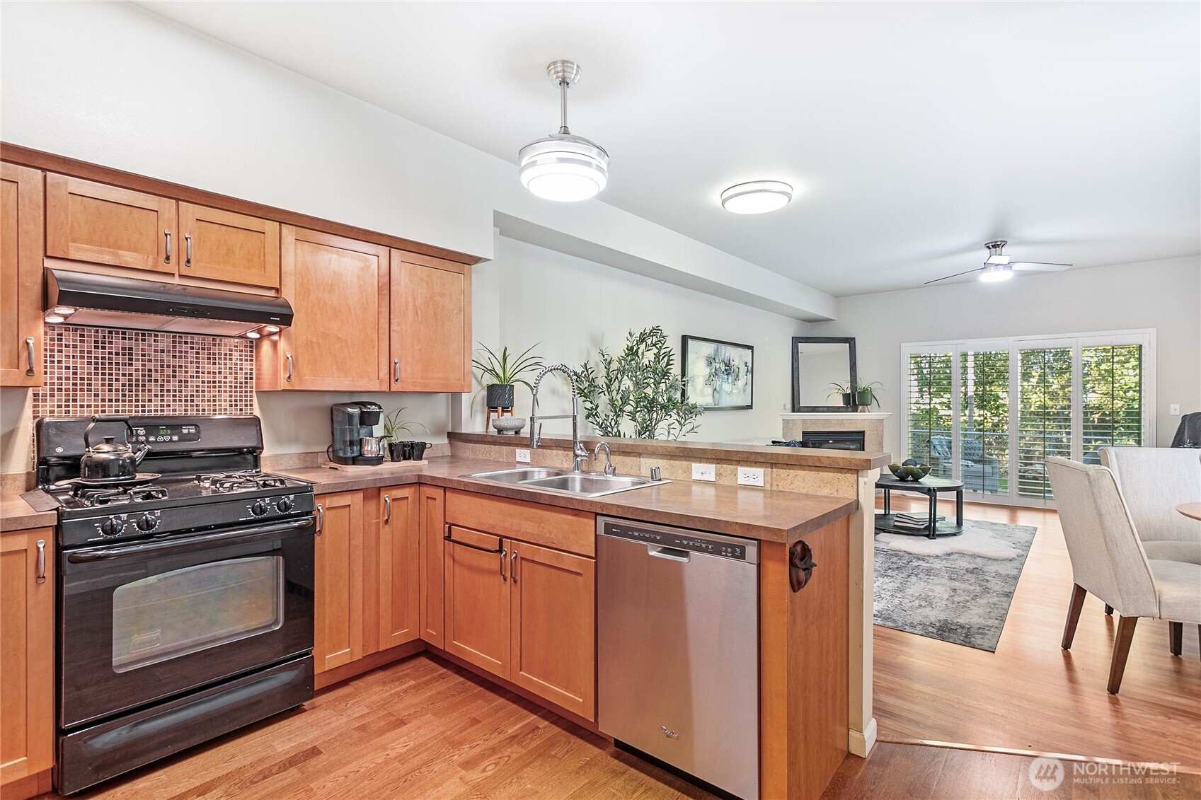 1384 Bayview Court, Unit E1 Blaine, WA 98230 - Photo 12 of 33 a kitchen with a stove a sink a dining table and chairs