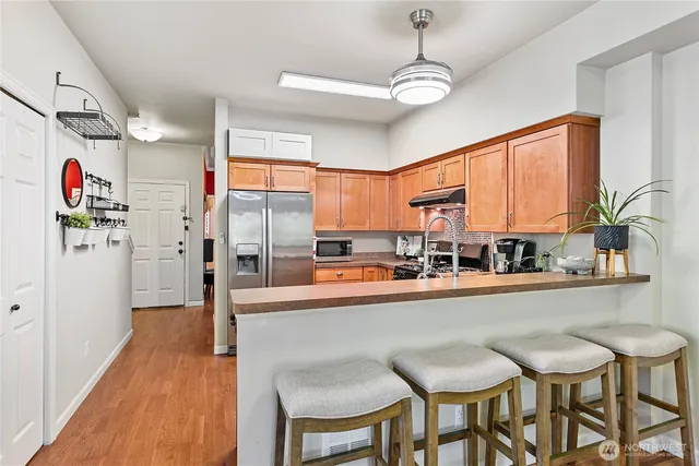 a dining table chairs next to a window with kitchen view
