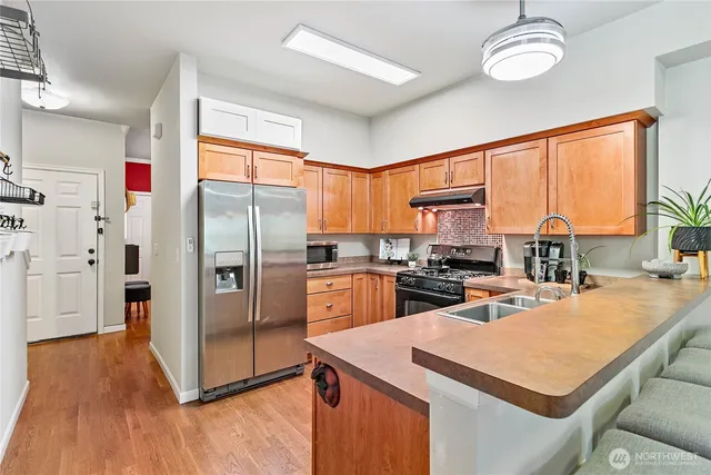a kitchen with a refrigerator a sink dishwasher with a dining table and chairs