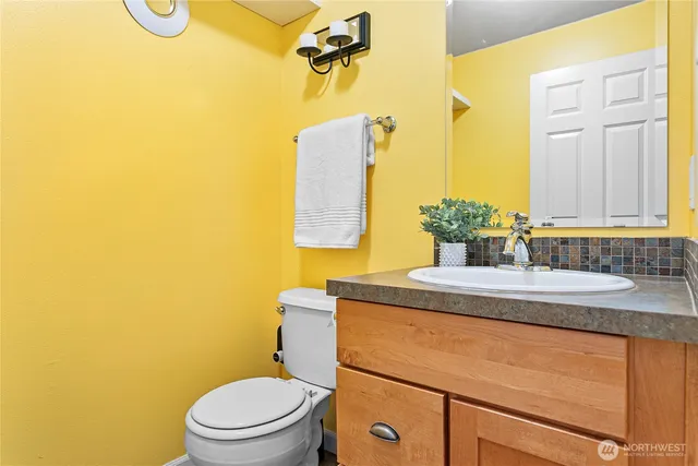 a bathroom with a granite countertop toilet sink and mirror