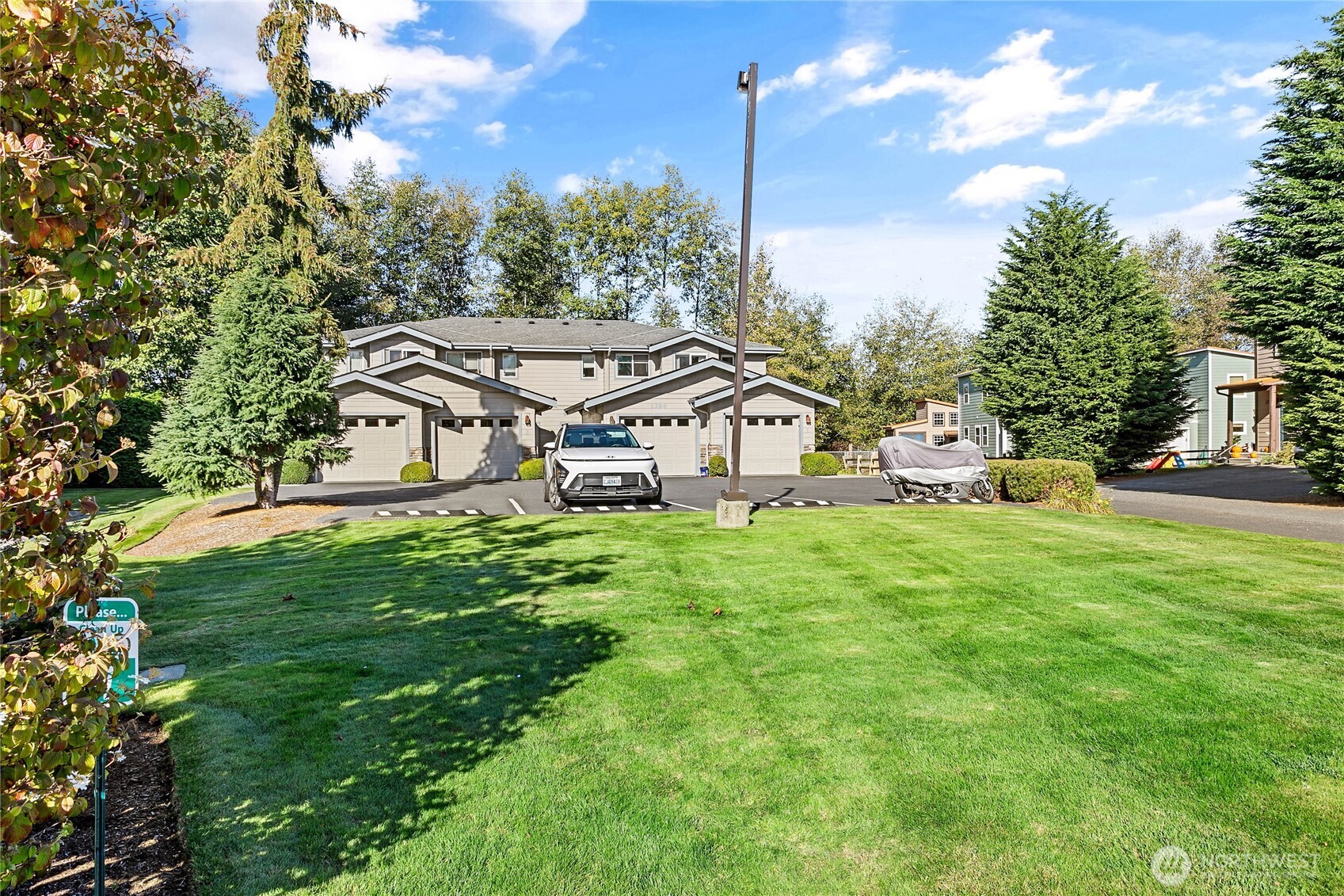 1384 Bayview Court, Unit E1 Blaine, WA 98230 - Photo 30 of 33 a white house with a small yard and large trees