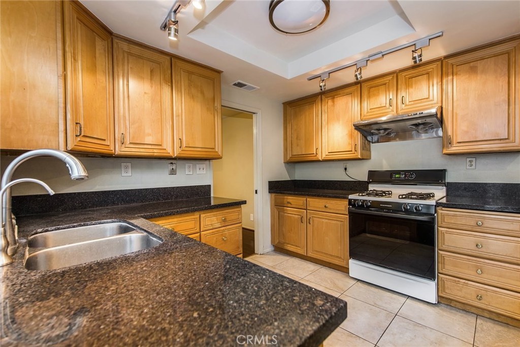 43 Morena Irvine, CA 92612 - Photo 17 of 42 a kitchen with granite countertop wooden cabinets stainless steel appliances and a window