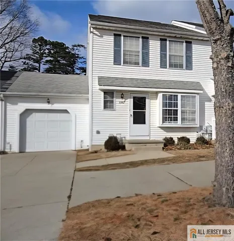 a front view of a house with garage and parking space