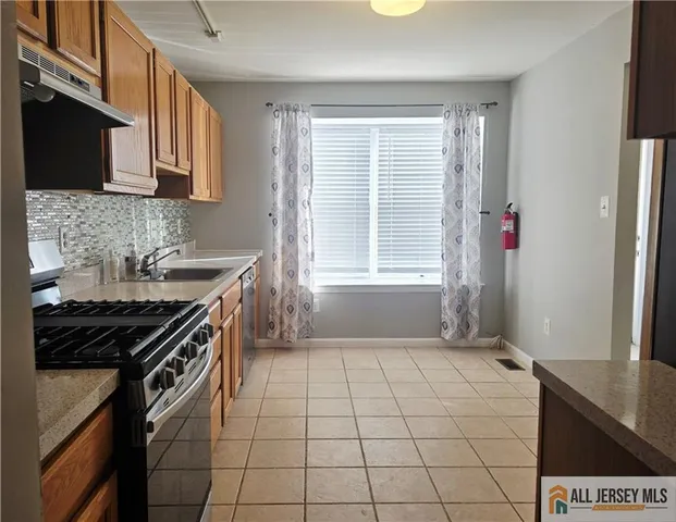 a kitchen that has a sink a stove and a window