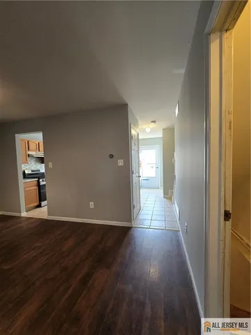 a view of a hallway with wooden floor and windows