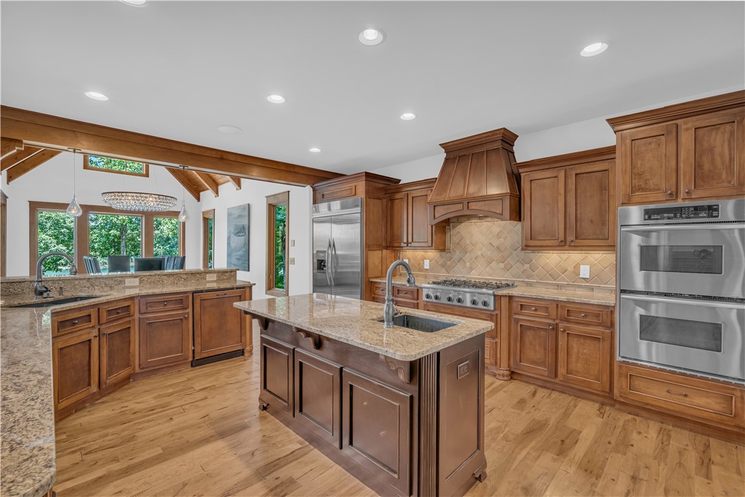 256 Talton Road Six Mile, SC 29682 - Photo 14 of 50 Rich wood cabinetry paired with granite countertops and hardwood flooring anchor this culinary space.