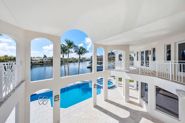 a spacious bedroom with a bed a mirror and a large window