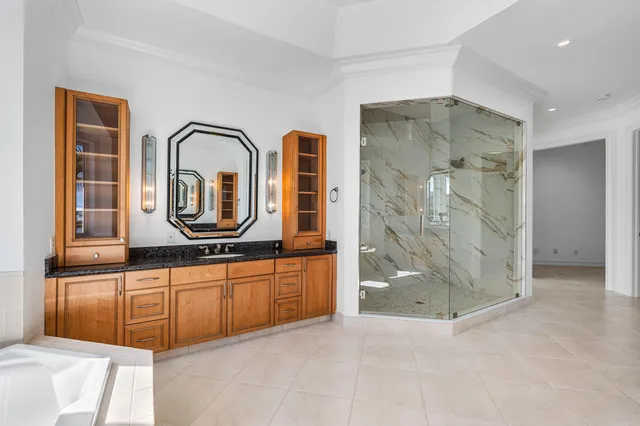a bathroom with a granite countertop sink a toilet and shower