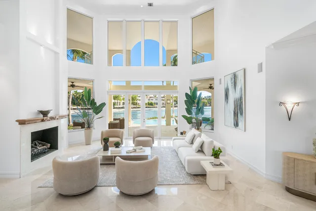 a living room with furniture floor to ceiling windows and a dining table