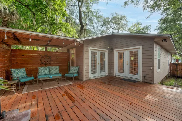 a backyard of a house with wooden floor a barbeque oven and outdoor seating