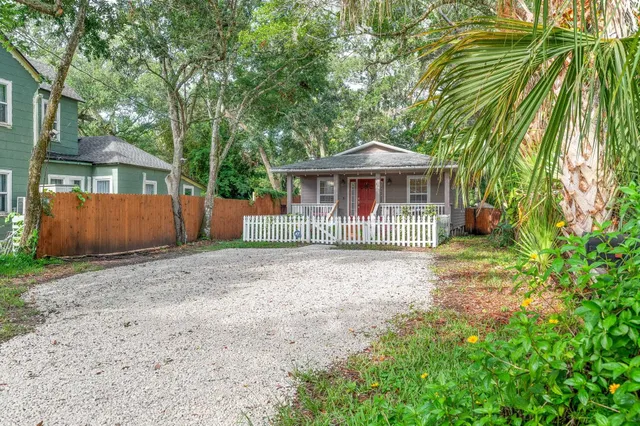 a view of a house with a small yard and a large tree