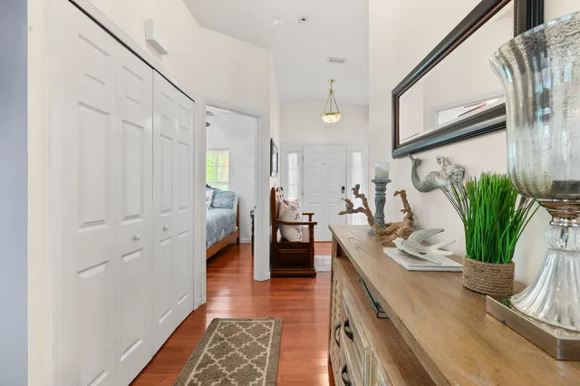 a hallway with white cabinets and wooden floor