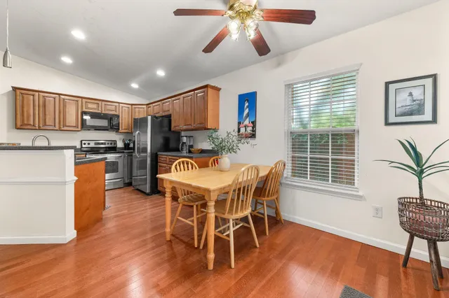 a kitchen with stainless steel appliances granite countertop a sink and a stove top oven with wooden floor