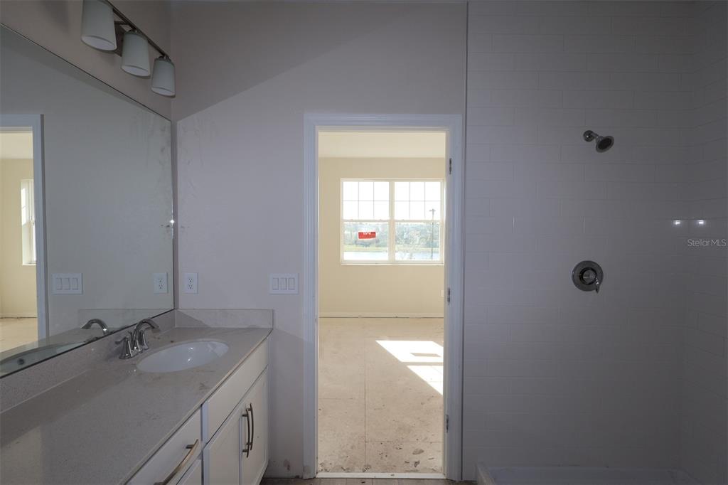 5204 Ctr Lk Rnch Boulevard St. Cloud, FL 34771 - Photo 14 of 24 a bathroom with a granite countertop sink a mirror and a shower