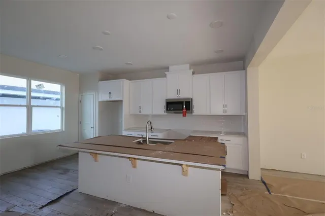 a kitchen with stainless steel appliances granite countertop a sink stove and cabinets
