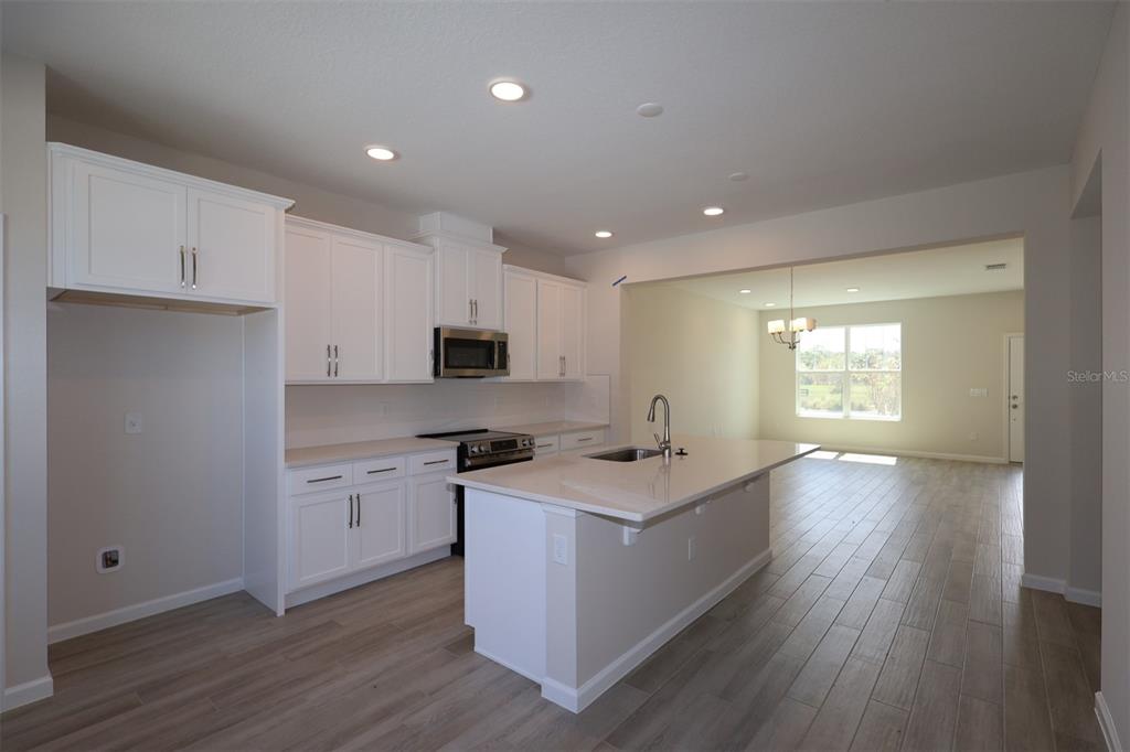 5204 Ctr Lk Rnch Boulevard St. Cloud, FL 34771 - Photo 4 of 24 a kitchen with stainless steel appliances granite countertop a sink a stove a refrigerator and cabinets