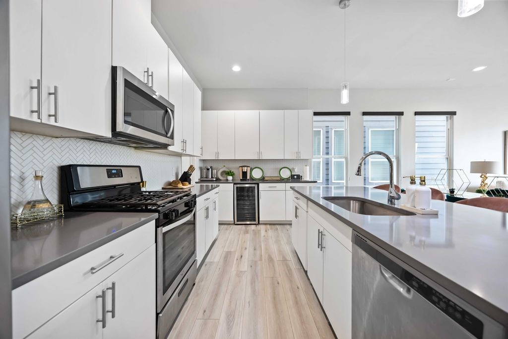 705 Gregg Street Houston, TX 77020 - Photo 14 of 27 a kitchen with stainless steel appliances granite countertop a stove top oven a sink and dishwasher with wooden floor