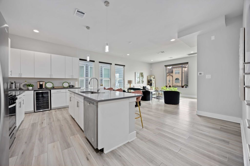 705 Gregg Street Houston, TX 77020 - Photo 15 of 27 a kitchen with stainless steel appliances granite countertop a refrigerator a stove top oven a sink dishwasher and white cabinets with wooden floor