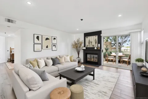 a view of an empty room with wooden floor fireplace and a window
