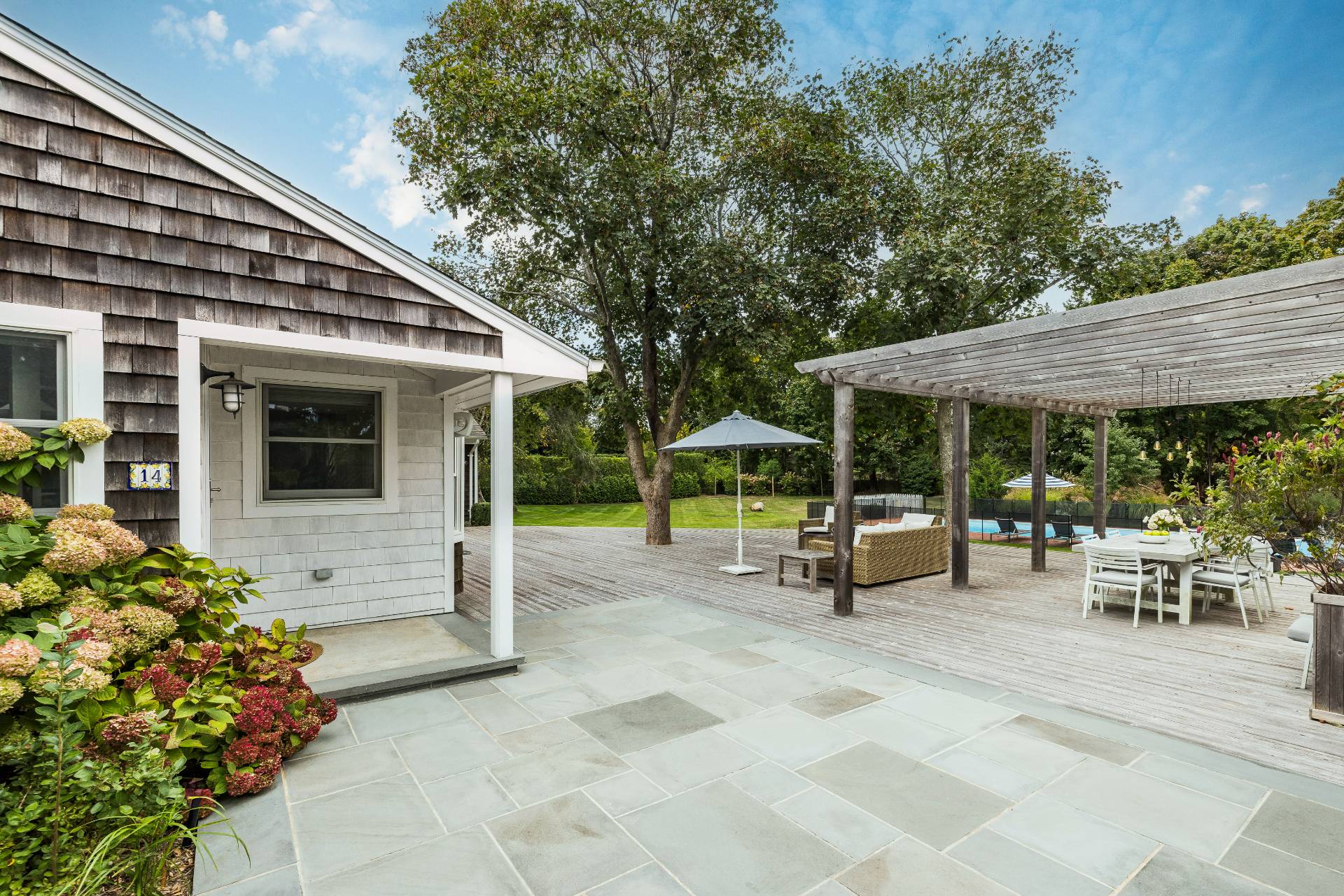 14 Sunset Road Sag Harbor, NY 11963 - Photo 13 of 19 a view of a patio with table and chairs under an umbrella
