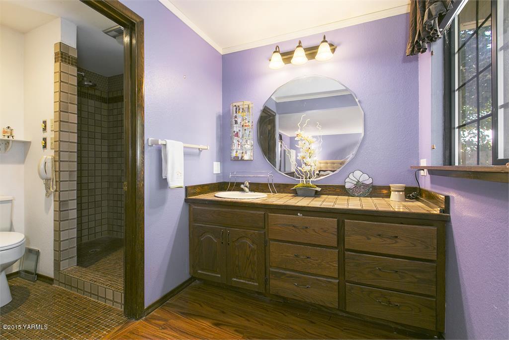 961 Gurley Road Granger, WA 98932 - Photo 14 of 34 a bathroom with a granite countertop sink a toilet and a mirror