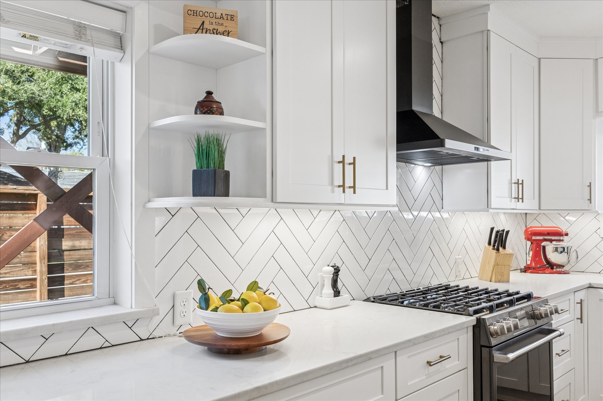 825 Merrill Street Houston, TX 77009 - Photo 14 of 37 White subway tile arranged in a herringbone pattern brings a fresh, modern touch to the bungalow.