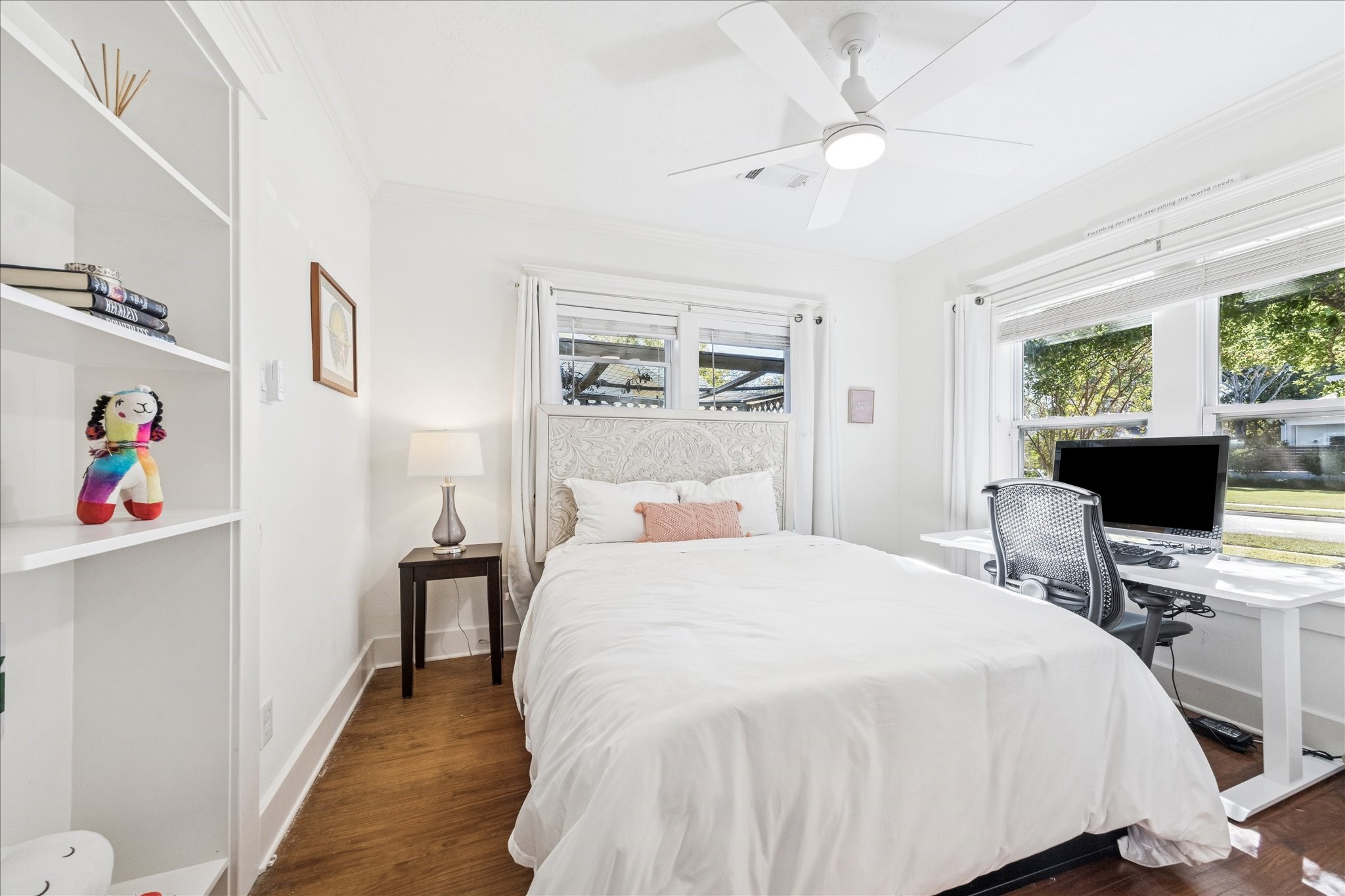 825 Merrill Street Houston, TX 77009 - Photo 26 of 37 Third bedroom featuring hardwood floors, crown molding, built-in shelves, ceiling fan, a closet, and views of the front yard. This versatile space would also make an ideal home office.