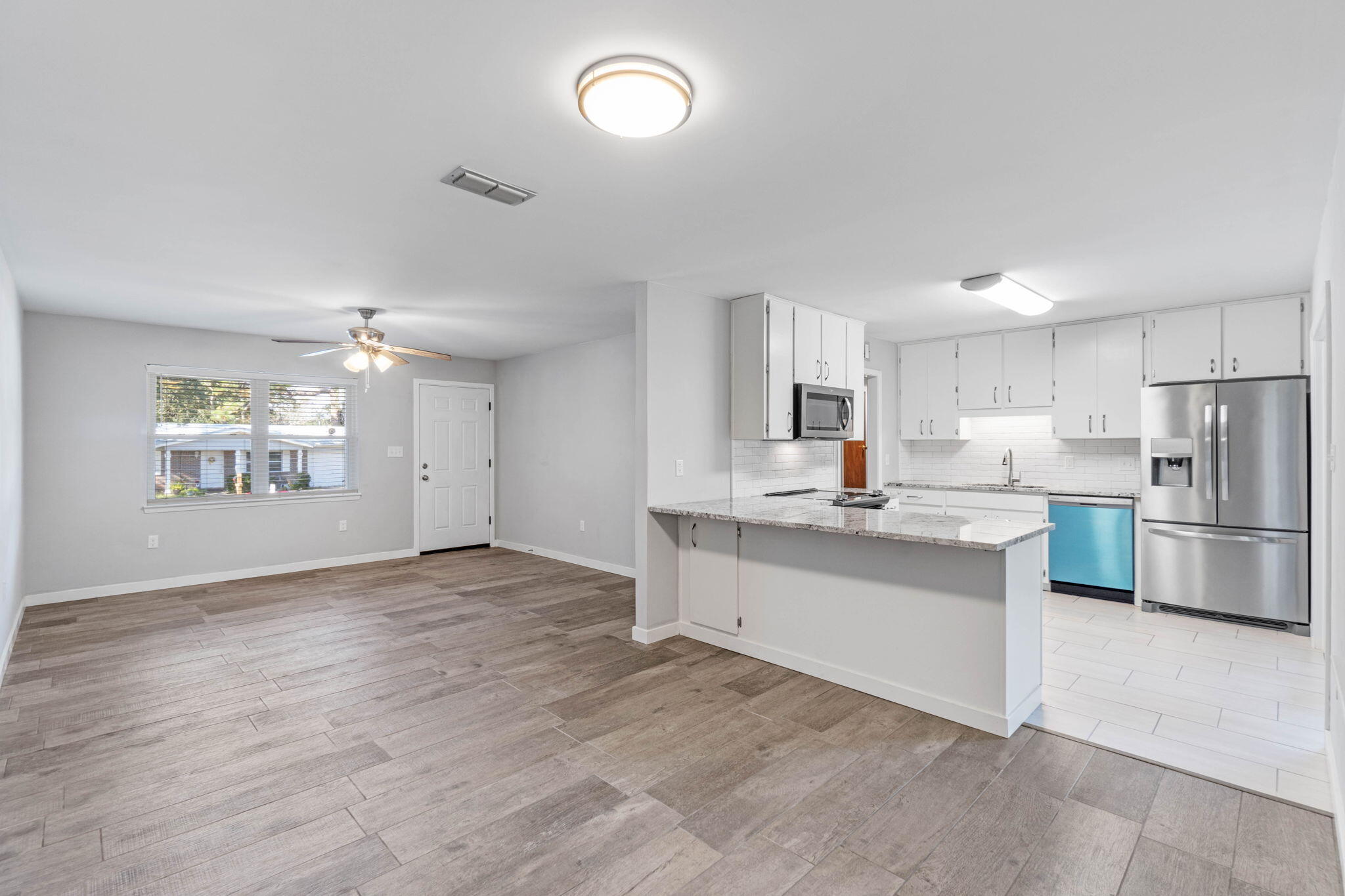 14 9th Street Shalimar, FL 32579 - Photo 8 of 29 a kitchen with white cabinets and stainless steel appliances
