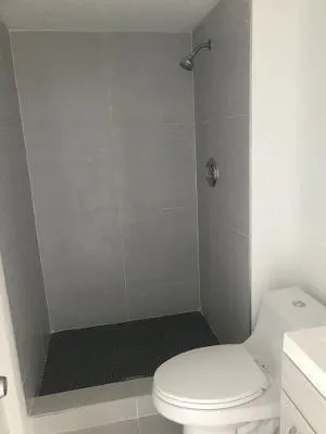 a white toilet sitting next to a shower