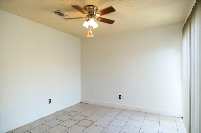 a view of a livingroom with a chandelier fan and windows
