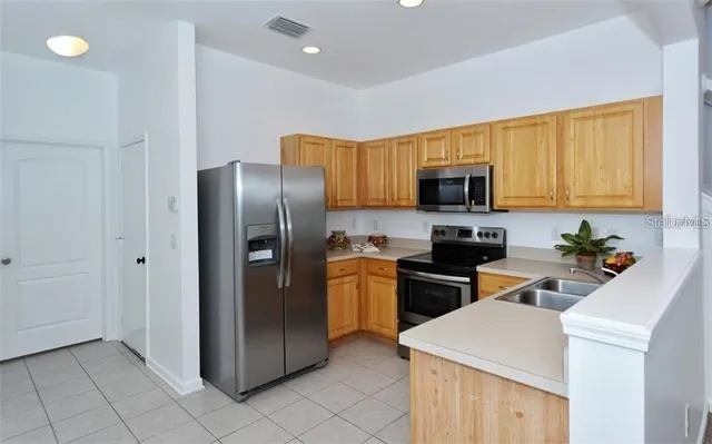a kitchen with stainless steel appliances granite countertop a refrigerator stove top oven a sink and dishwasher
