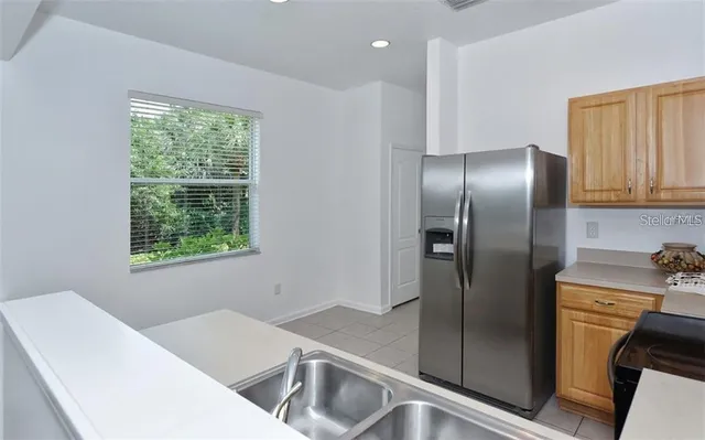 a kitchen with stainless steel appliances granite countertop a refrigerator and a sink