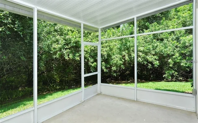 a view of a chair and table in backyard of the house