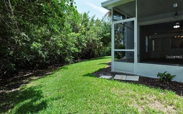 a view of a backyard with potted plants and large trees