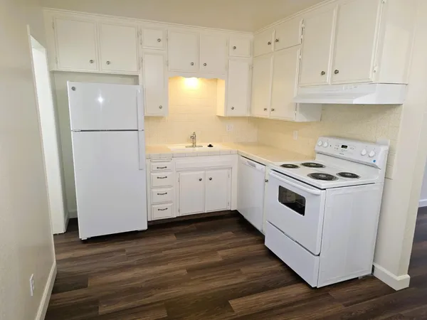 a kitchen with white cabinets and white appliances