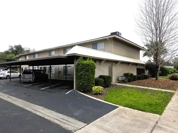a view of a house with a yard and sitting area