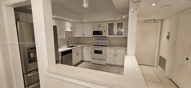 a kitchen with white cabinets and stainless steel appliances