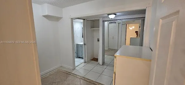 an empty room with wooden floor and cabinet