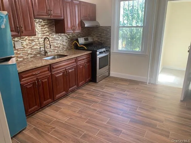 a kitchen with stainless steel appliances granite countertop a stove a sink and a microwave