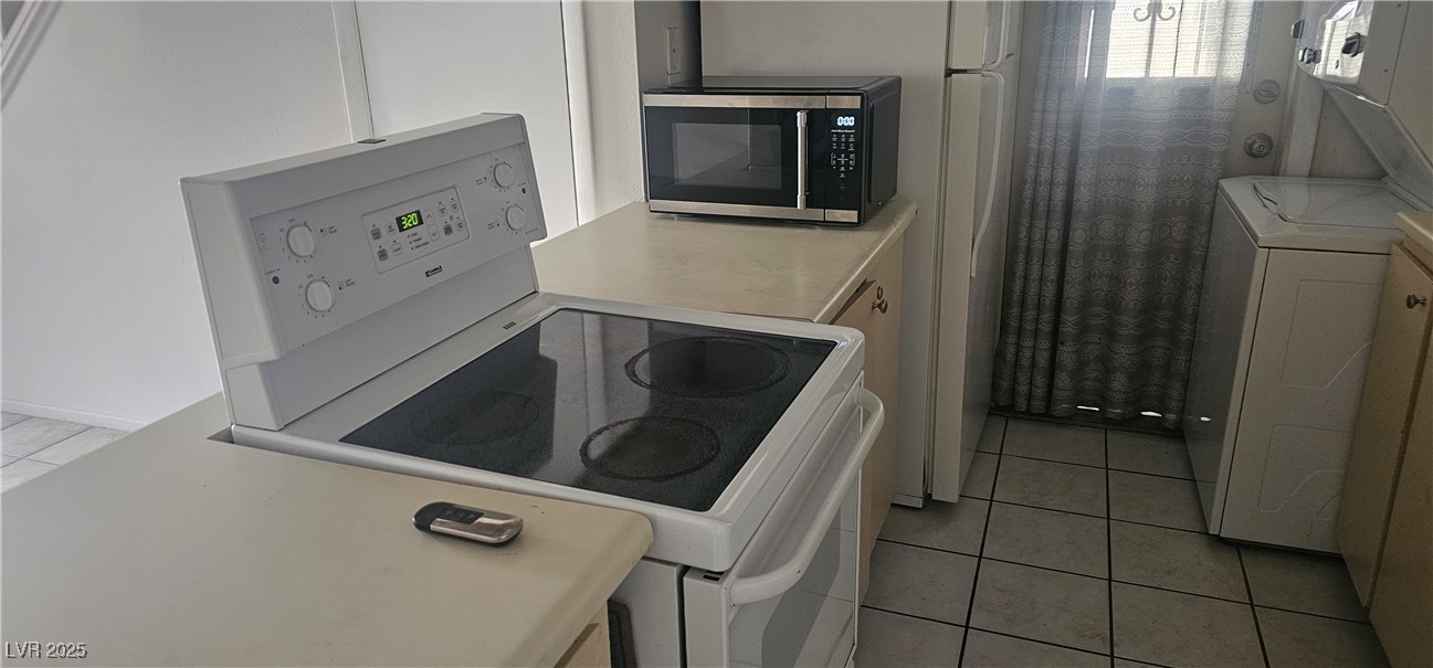 1344 Lorilyn Avenue, Unit 2 Las Vegas, NV 89119 - Photo 3 of 15 Washroom with light tile patterned floors and washer / clothes dryer