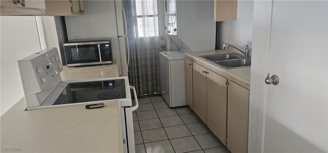 1344 Lorilyn Avenue, Unit 2 Las Vegas, NV 89119 - Photo 4 of 15 Kitchen featuring light countertops, electric stove, light tile patterned flooring, stainless steel microwave, and light brown cabinets