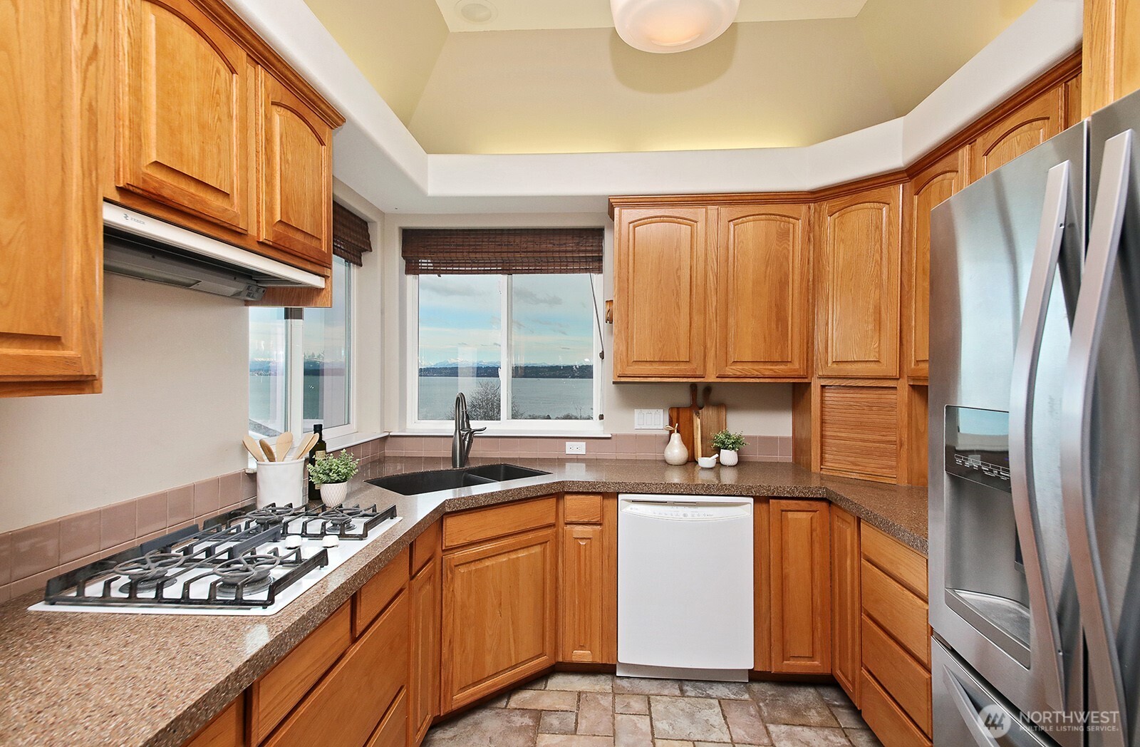 4694 Wrightsman Place Clinton, WA 98236 - Photo 8 of 38 a kitchen with stainless steel appliances granite countertop a sink a stove and a refrigerator