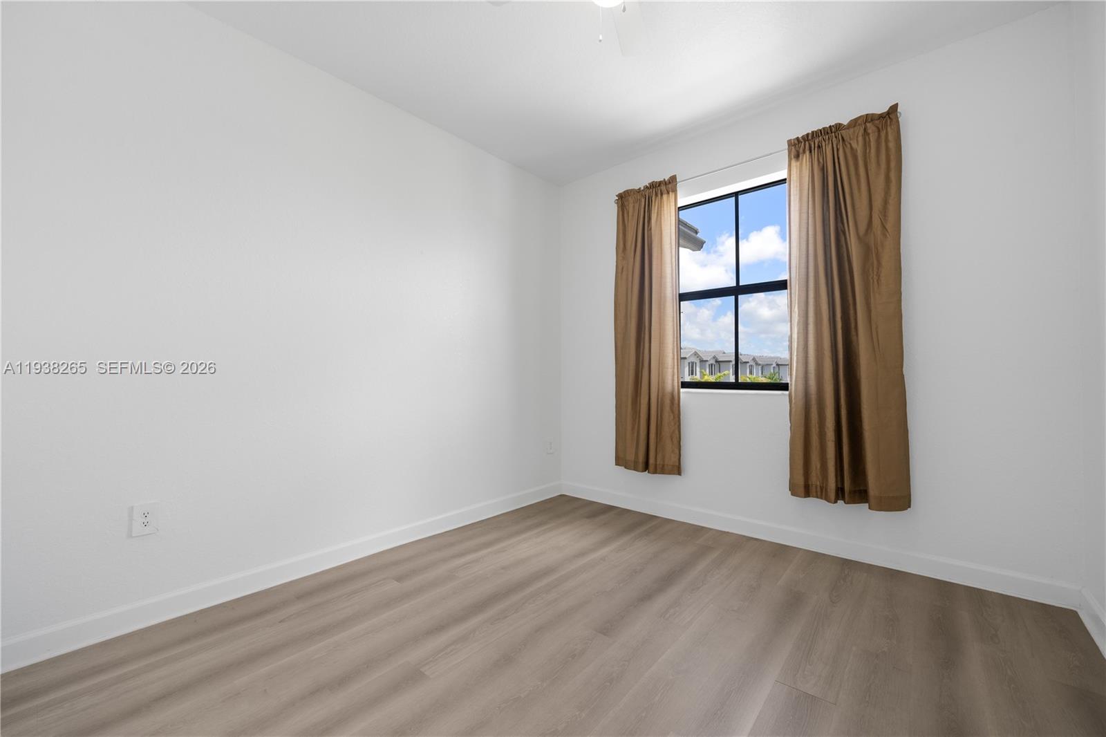 13388 Southwest 286th Street Homestead, FL 33033 - Photo 16 of 46 an empty room with wooden floor and windows