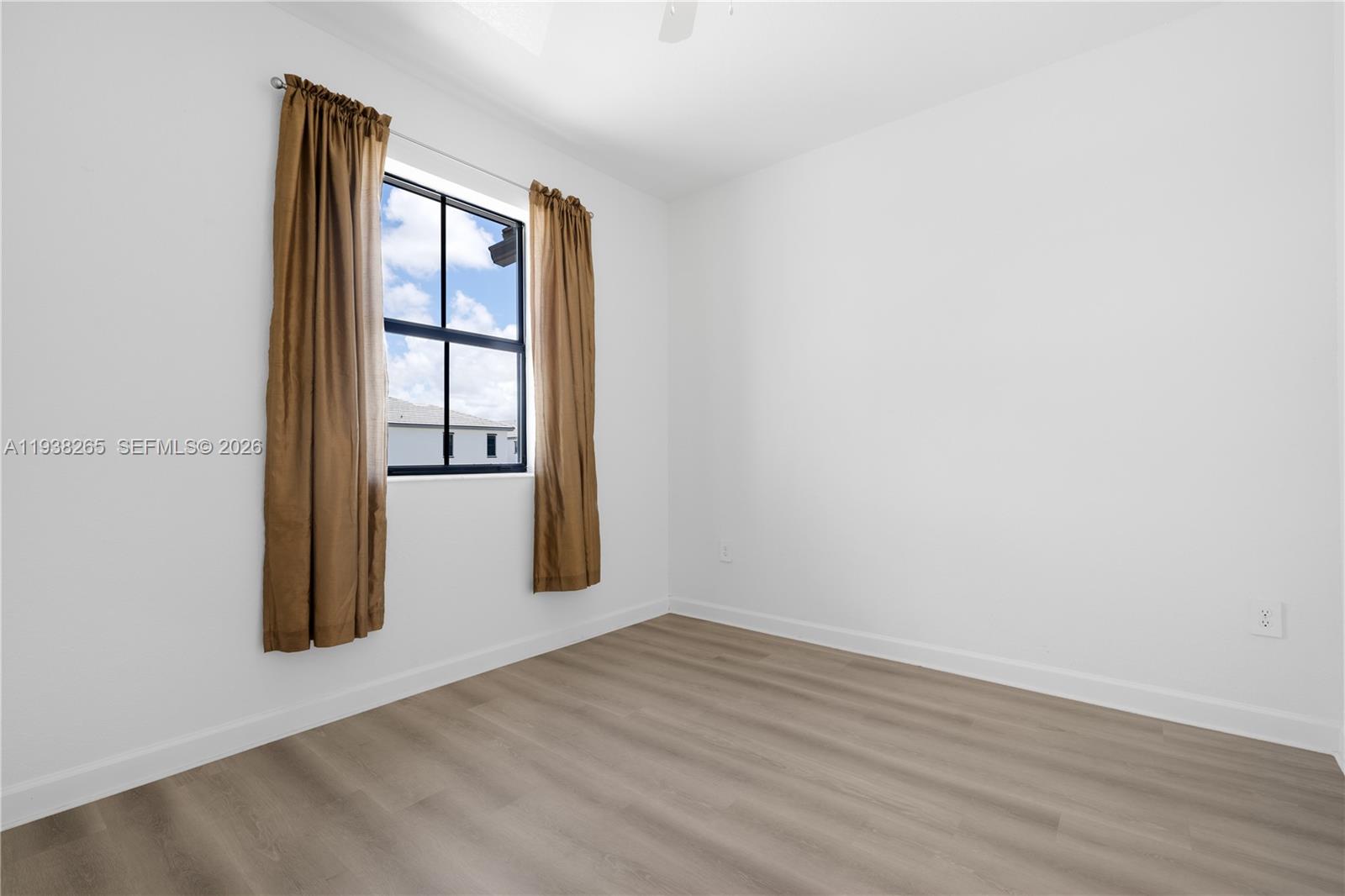 13388 Southwest 286th Street Homestead, FL 33033 - Photo 20 of 46 an empty room with wooden floor and windows