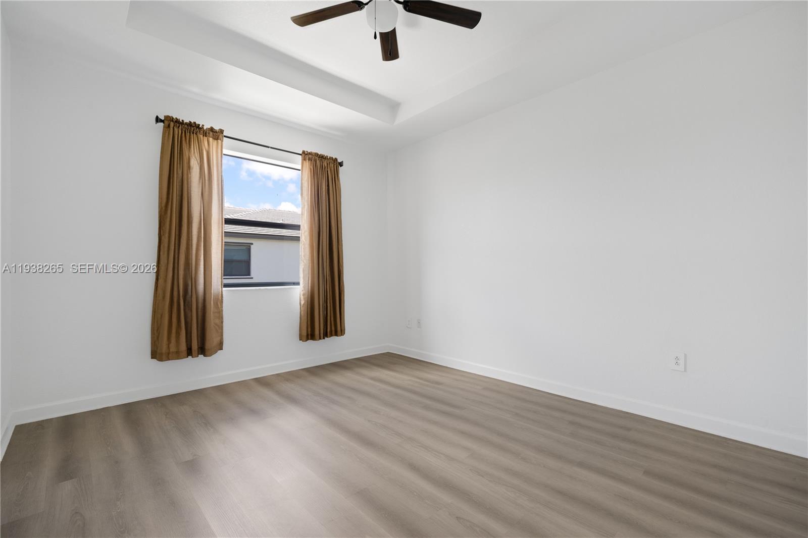 13388 Southwest 286th Street Homestead, FL 33033 - Photo 22 of 46 an empty room with wooden floor ceiling fan and windows