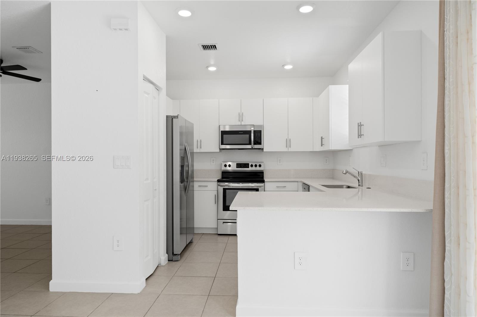 13388 Southwest 286th Street Homestead, FL 33033 - Photo 7 of 46 a kitchen with a refrigerator and a microwave