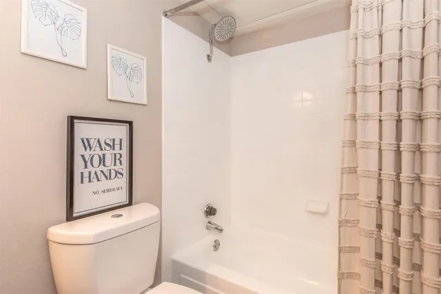 a white toilet sitting next to a shower curtain