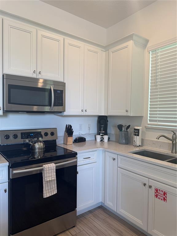 2986 Salted Rim Road Kissimmee, FL 34747 - Photo 6 of 32 a kitchen with stainless steel appliances granite countertop white cabinets a sink a stove and a microwave