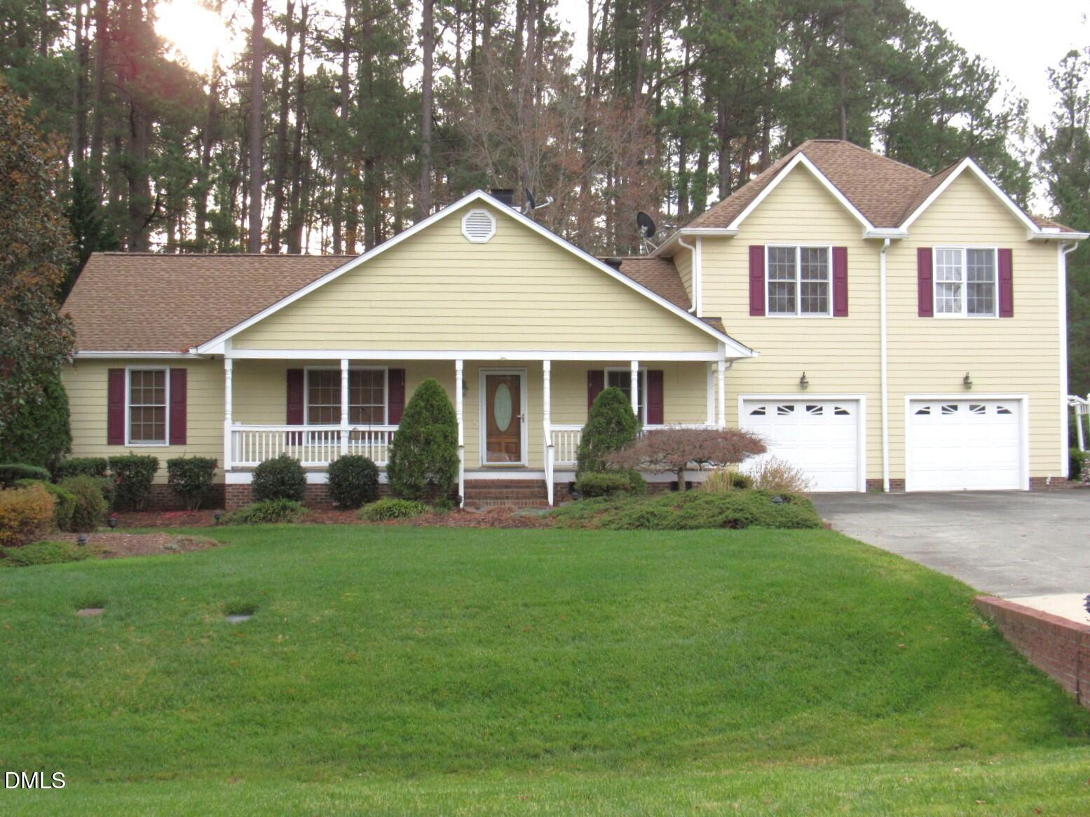 a front view of a house with a yard and trees